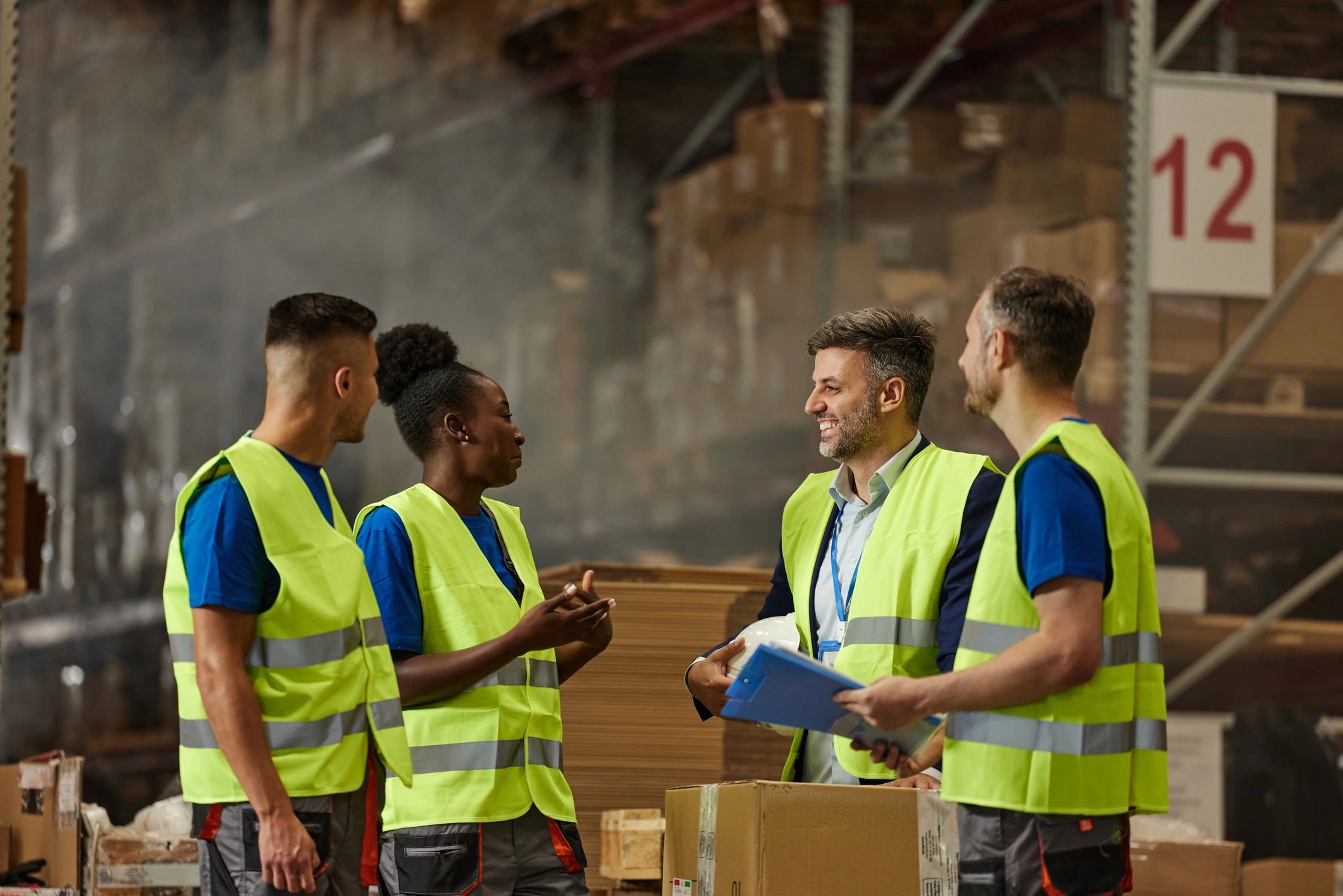 Warehouse supervisor speaking with team in distribution area